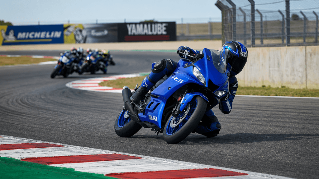 Yamaha R3 azul en circuito inclinando en curva